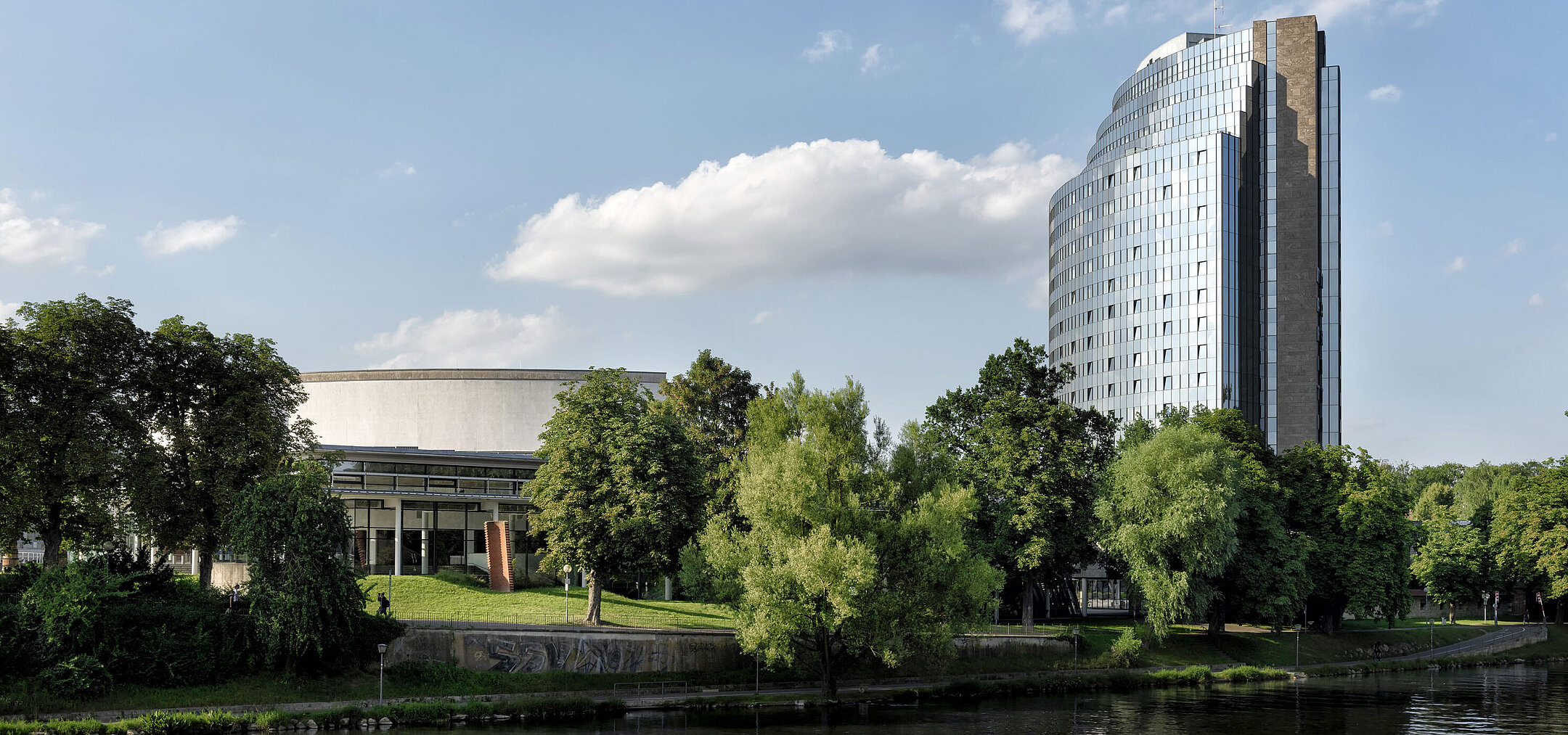 Maritim Hotel Ulm mit Blick auf die Donau, umgeben von viel Grün und moderner Architektur