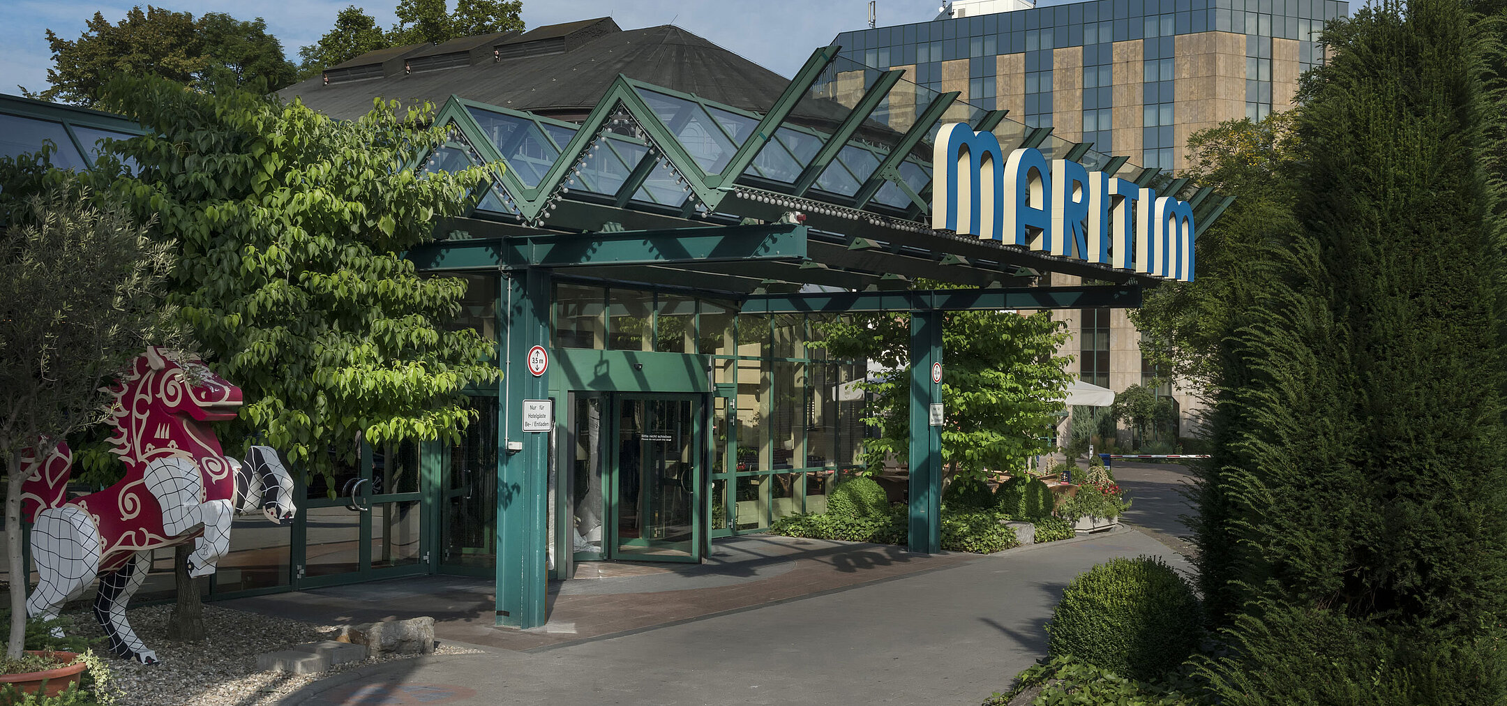 Haupteingang des Maritim Hotel Stuttgart mit Glasdach, grünem Eingangsbereich und Maritim-Schriftzug